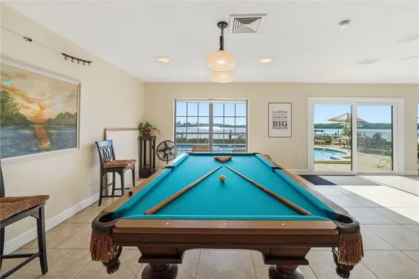 a room with pool table and windows
