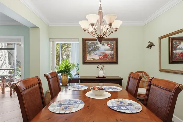 a view of a dining room with furniture a chandelier and wooden floor