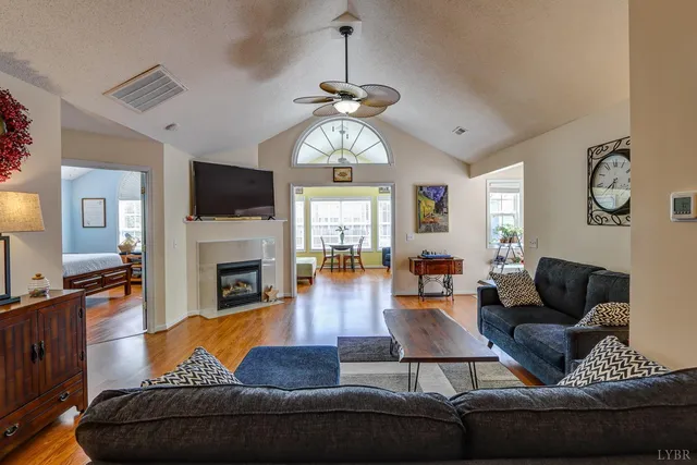 a living room with furniture a fireplace and a flat screen tv