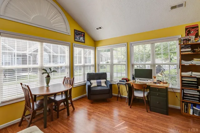 a view of a workspace with furniture and a window