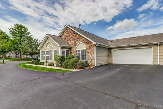 a view of a house with a yard and large trees