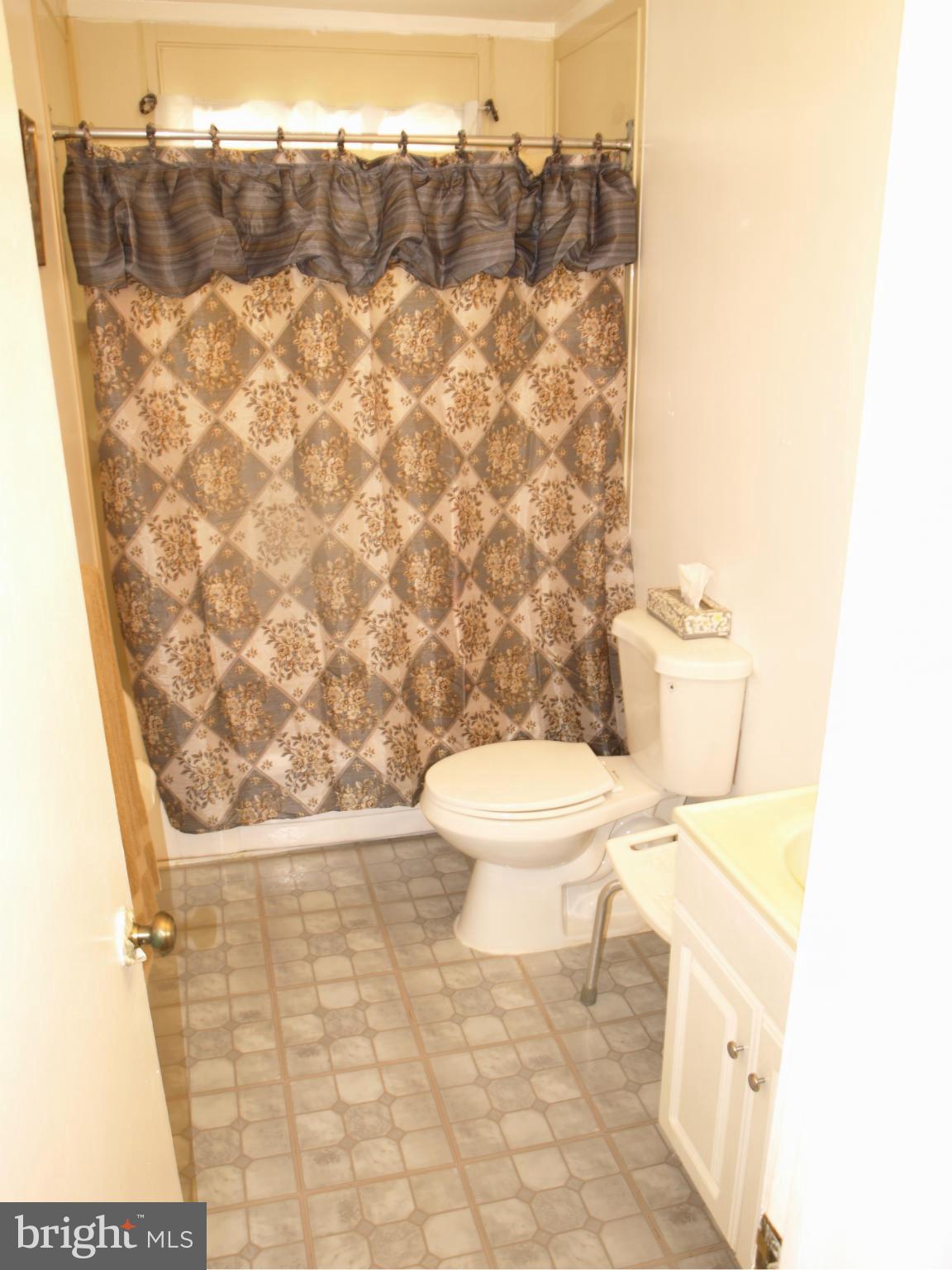 1211 Gettig Road Baltimore, MD 21237 - Photo 6 of 30 a bathroom with a toilet and a shower curtain
