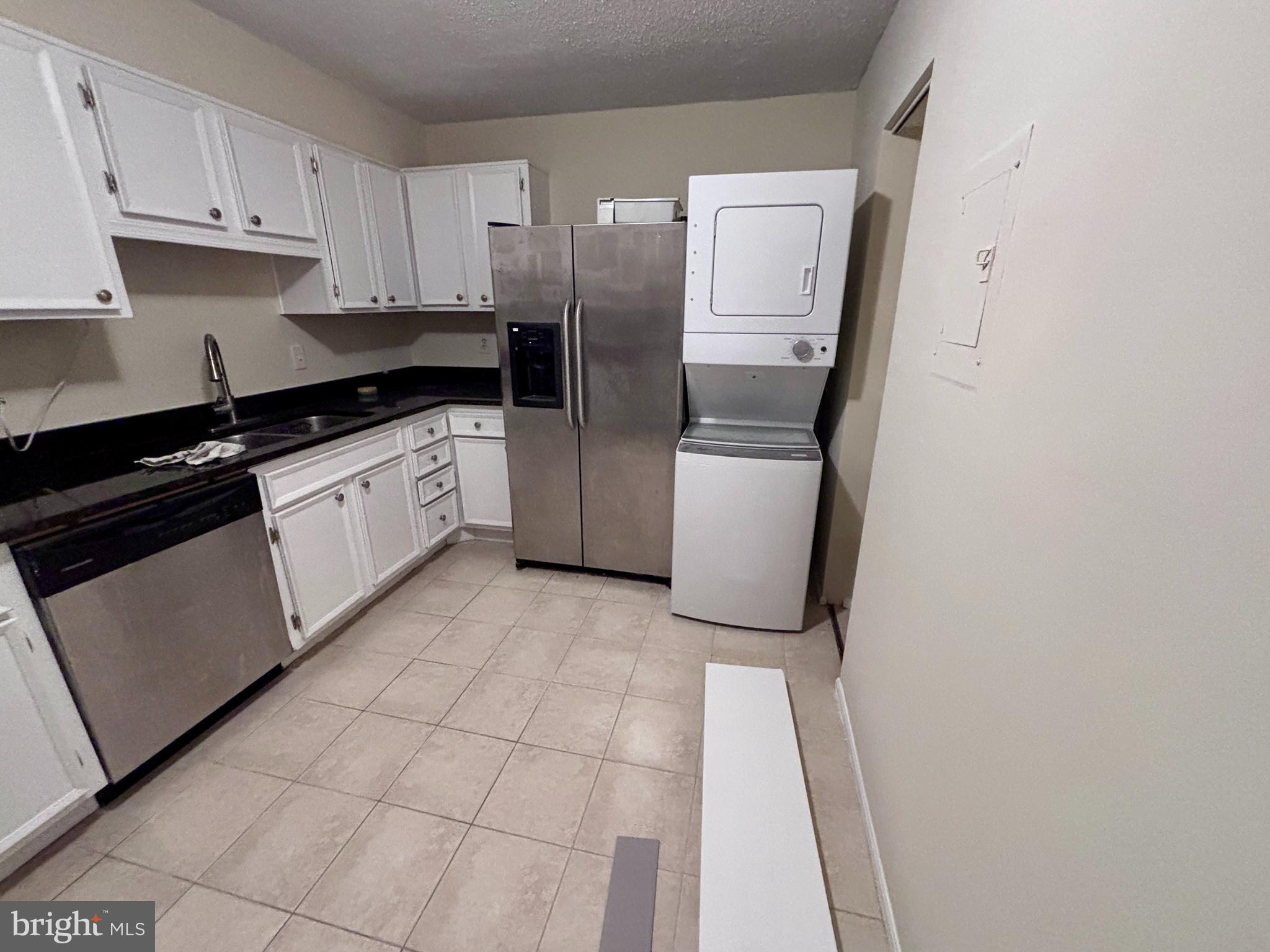 5901 Mt Eagle Drive, Unit 1009 Alexandria, VA 22303 - Photo 6 of 17 a kitchen with a refrigerator and white cabinets
