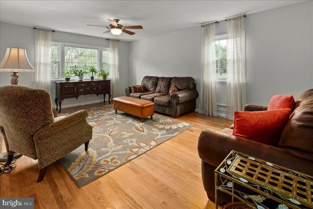 a living room with furniture ceiling fan and a window