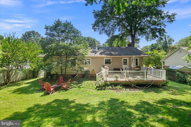 a front view of a house with a garden and lake view