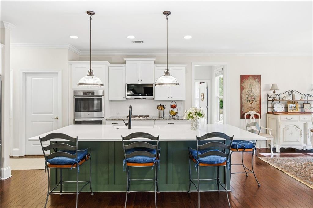 91 Bellwind Lane Dallas, GA 30132 - Photo 11 of 44 a kitchen with stainless steel appliances kitchen island granite countertop a stove top oven a sink a dining table and chairs