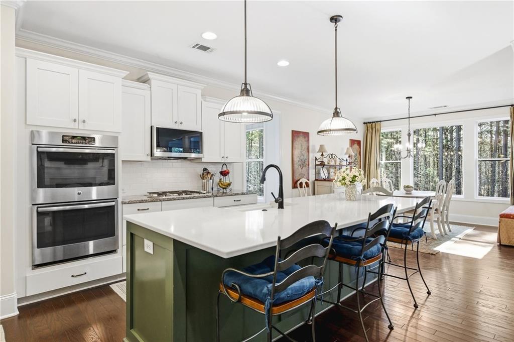 91 Bellwind Lane Dallas, GA 30132 - Photo 12 of 44 a kitchen with stainless steel appliances granite countertop a stove a sink a microwave a dining table and chairs