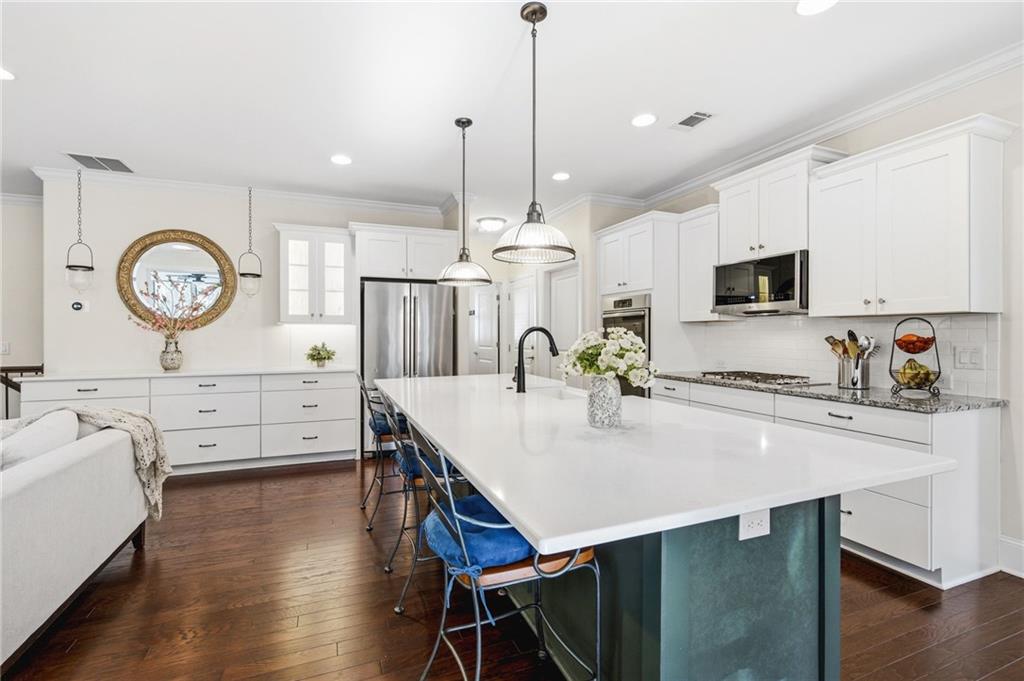 91 Bellwind Lane Dallas, GA 30132 - Photo 13 of 44 a large kitchen with kitchen island a stove a table a sink and cabinets