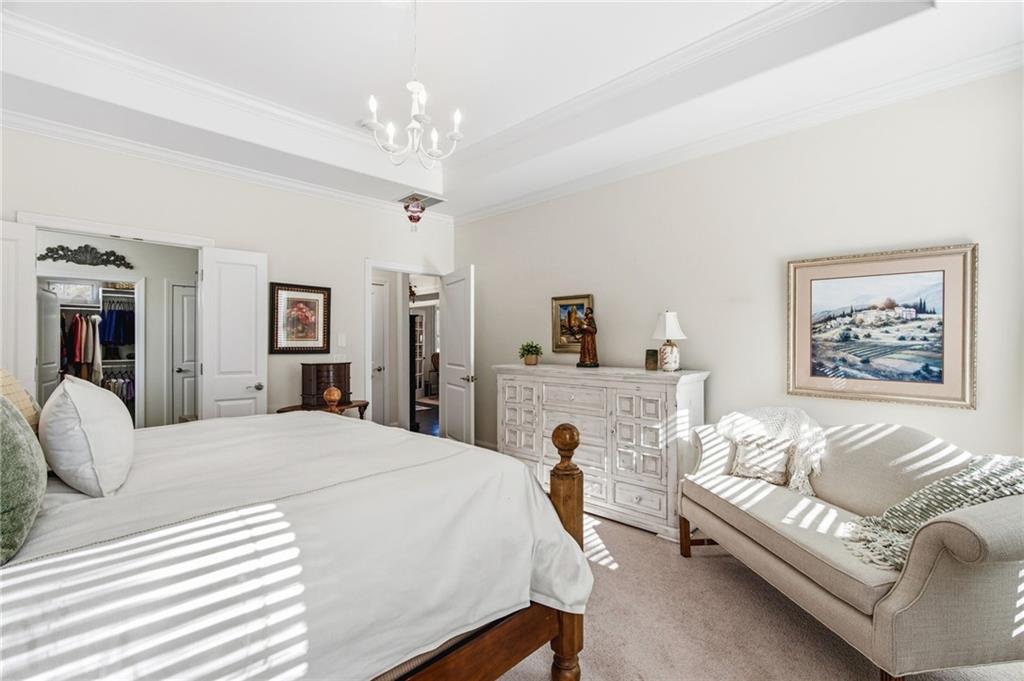 91 Bellwind Lane Dallas, GA 30132 - Photo 23 of 44 a bedroom with a large bed a couch and potted plant on the dresser