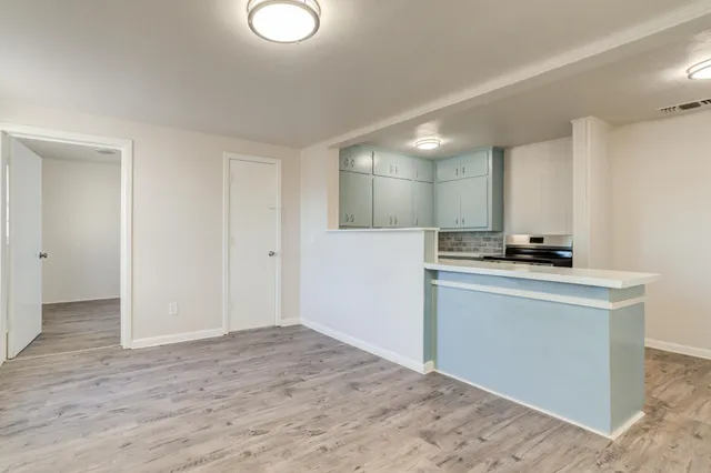 a view of kitchen with granite countertop cabinets and black appliances