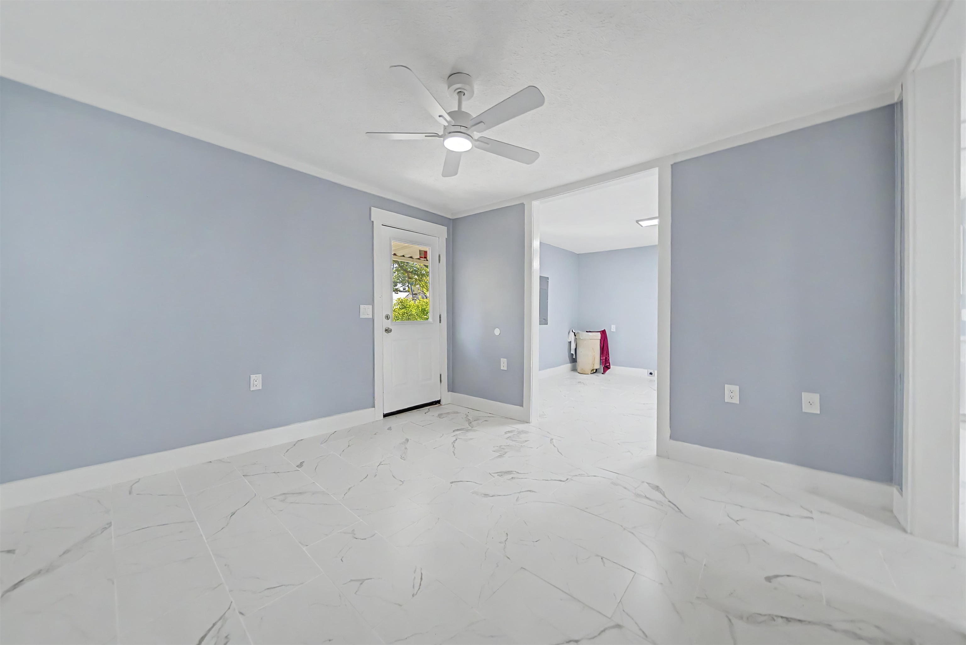 7437 Highway 45 Ramer, TN 38367 - Photo 35 of 36 Spacious room featuring light blue walls, white trim, a ceiling fan, and white tile flooring
