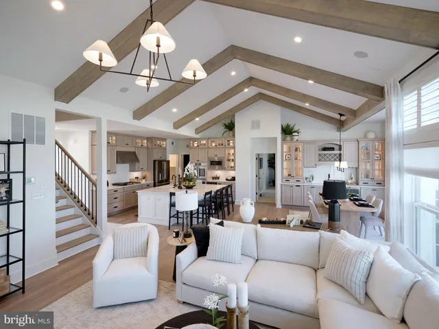 a living room with furniture kitchen view and a chandelier