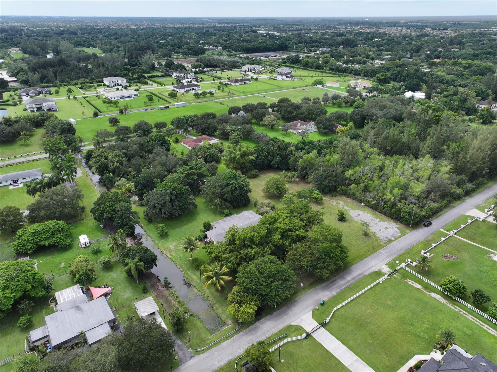 18100 Southwest 55th Street Southwest Ranches, FL 33331 - Photo 2 of 16 an aerial view of green landscape with trees houses and mountain view