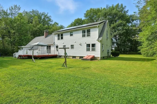 a view of a house with a backyard and a tree