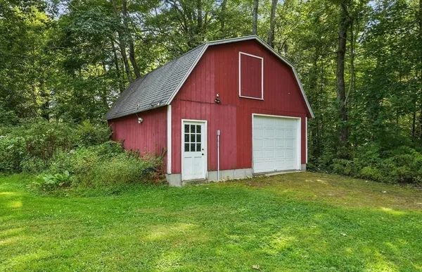 a view of a yard in front of a house with large trees