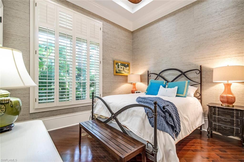 2220 Miramonte Court Naples, FL 34105 - Photo 20 of 35 a bedroom with a bed a mirror and a large window
