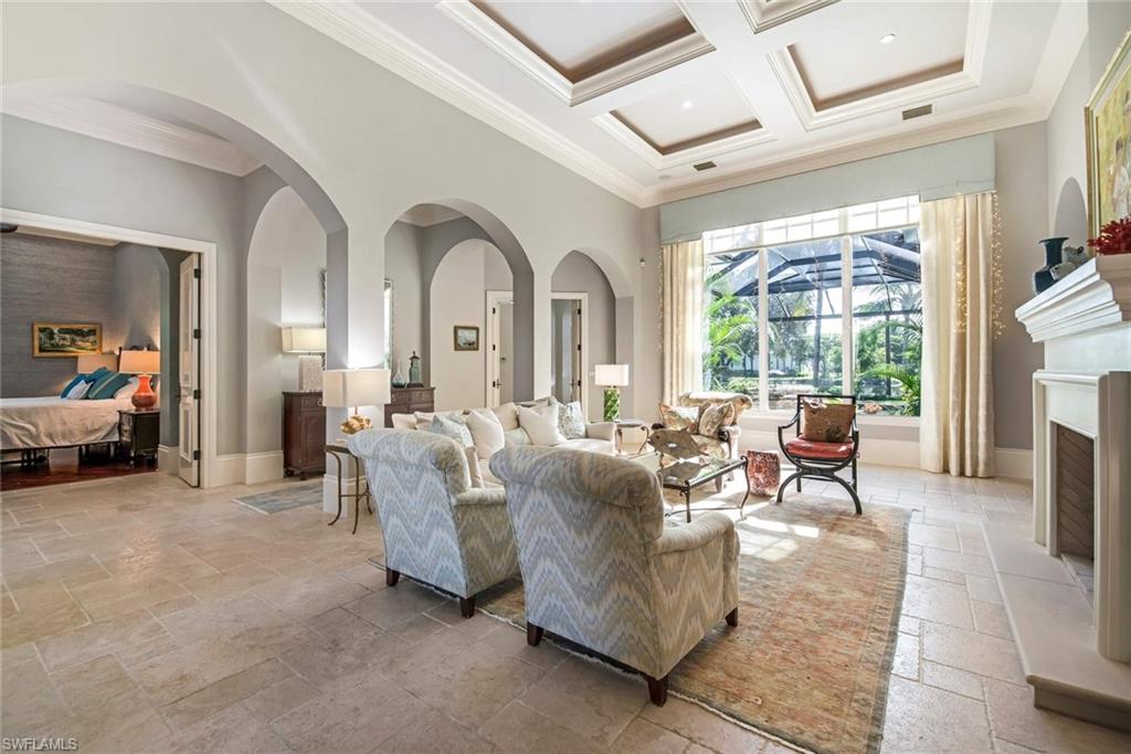 2220 Miramonte Court Naples, FL 34105 - Photo 2 of 35 a living room with furniture a fireplace and a large window