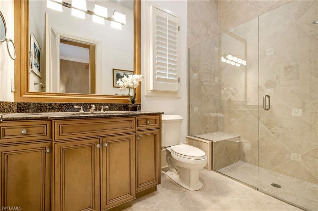 2220 Miramonte Court Naples, FL 34105 - Photo 24 of 35 a bathroom with a granite countertop sink toilet and shower