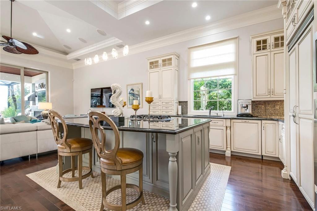 2220 Miramonte Court Naples, FL 34105 - Photo 6 of 35 a kitchen with a table chairs stove and refrigerator