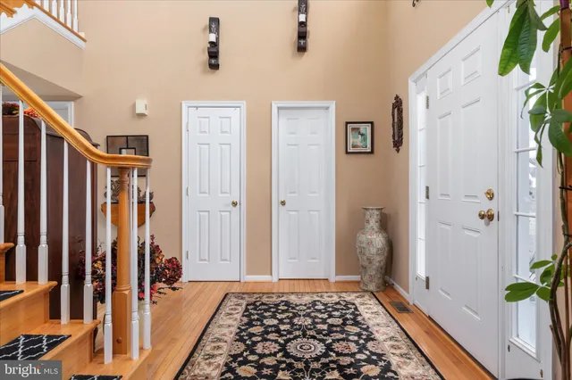 a view of a hallway with wooden floor and cabinets