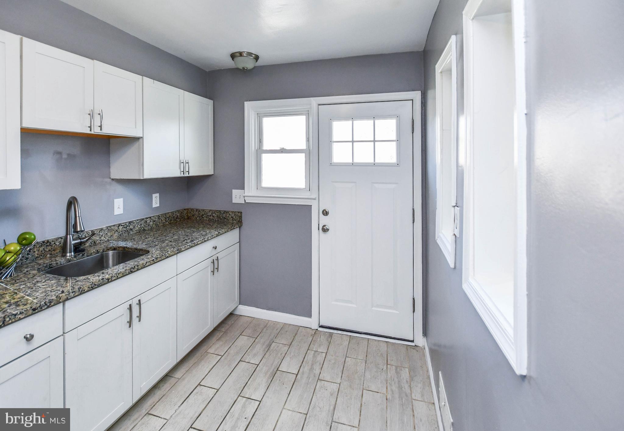 1028 Evesham Avenue Baltimore, MD 21212 - Photo 17 of 49 a kitchen with granite countertop white cabinets and sink