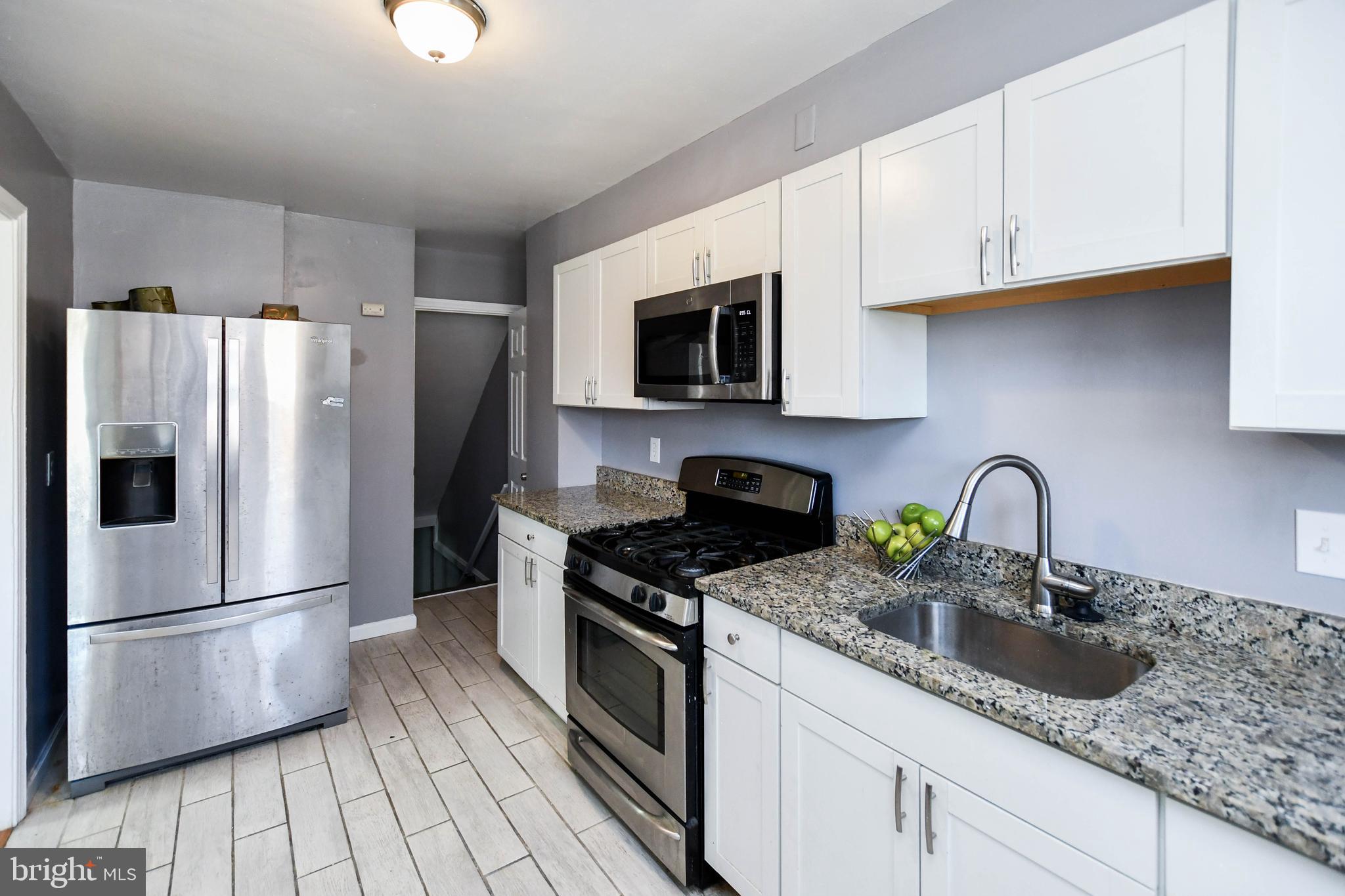 1028 Evesham Avenue Baltimore, MD 21212 - Photo 19 of 49 a kitchen with granite countertop a refrigerator stove and sink