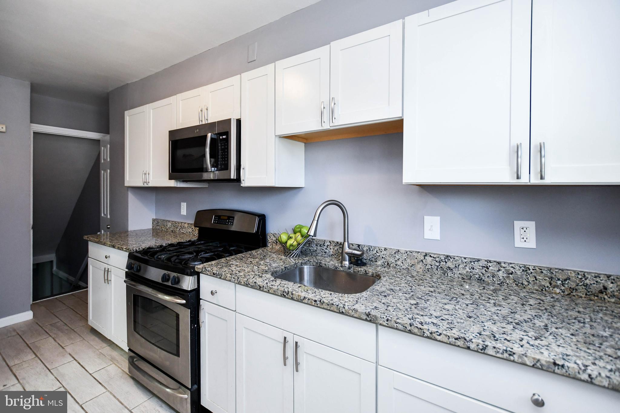 1028 Evesham Avenue Baltimore, MD 21212 - Photo 20 of 49 a kitchen with granite countertop white cabinets stainless steel appliances and a sink