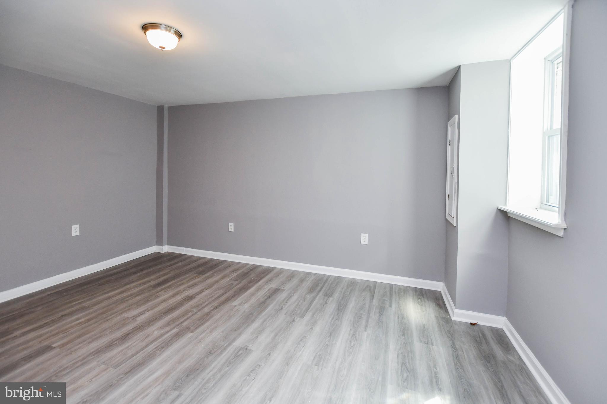 1028 Evesham Avenue Baltimore, MD 21212 - Photo 38 of 49 a view of an empty room with wooden floor and a window
