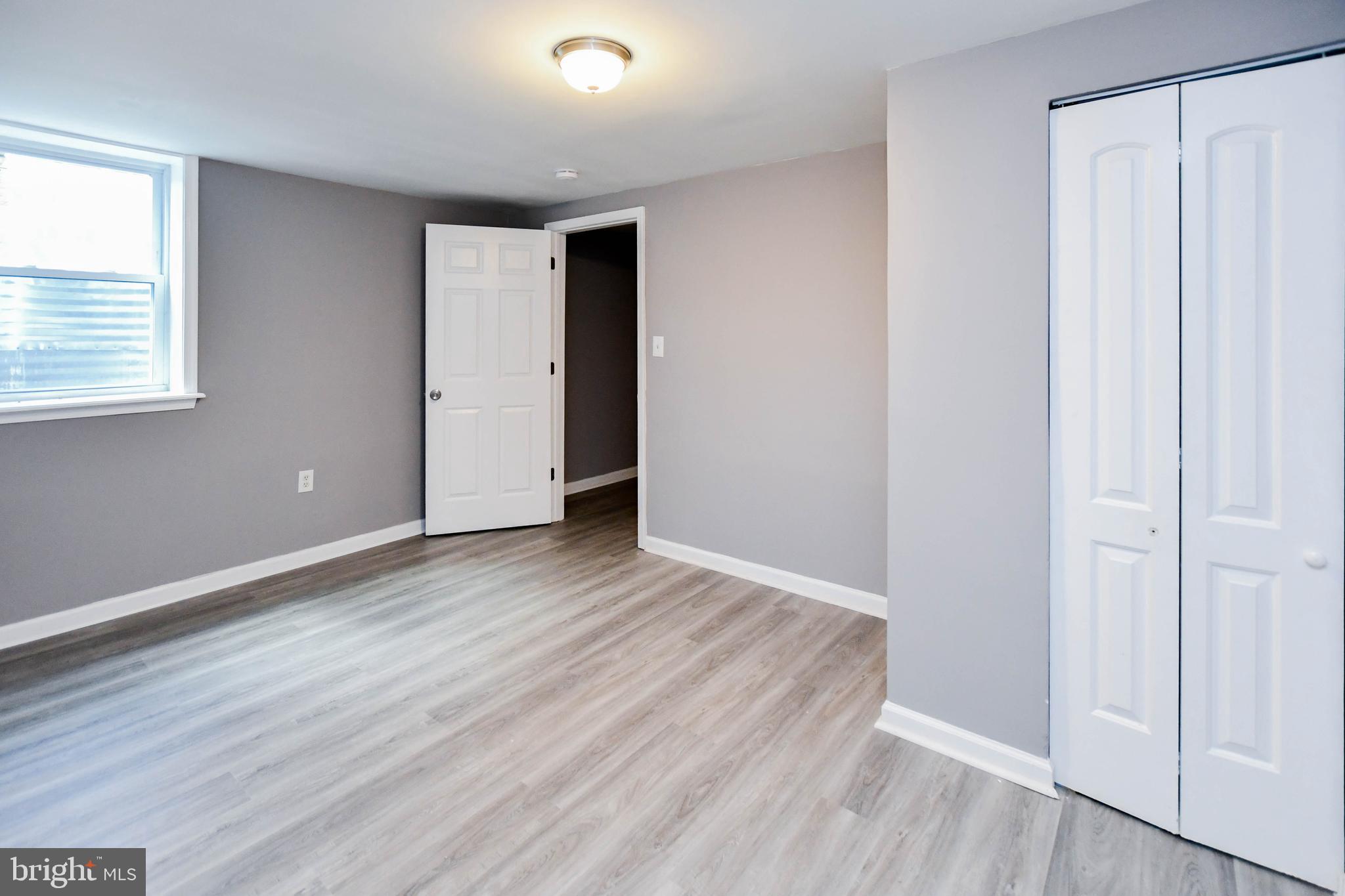 1028 Evesham Avenue Baltimore, MD 21212 - Photo 40 of 49 an empty room with wooden floor and windows