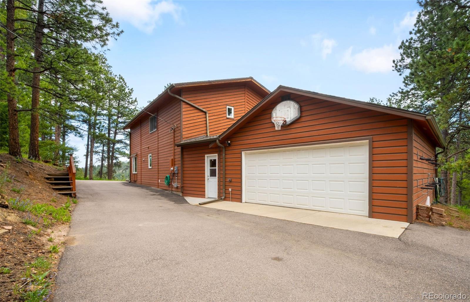 9633 Fox Valley Drive Morrison, CO 80465 - Photo 47 of 50 a front view of a house with a yard and garage
