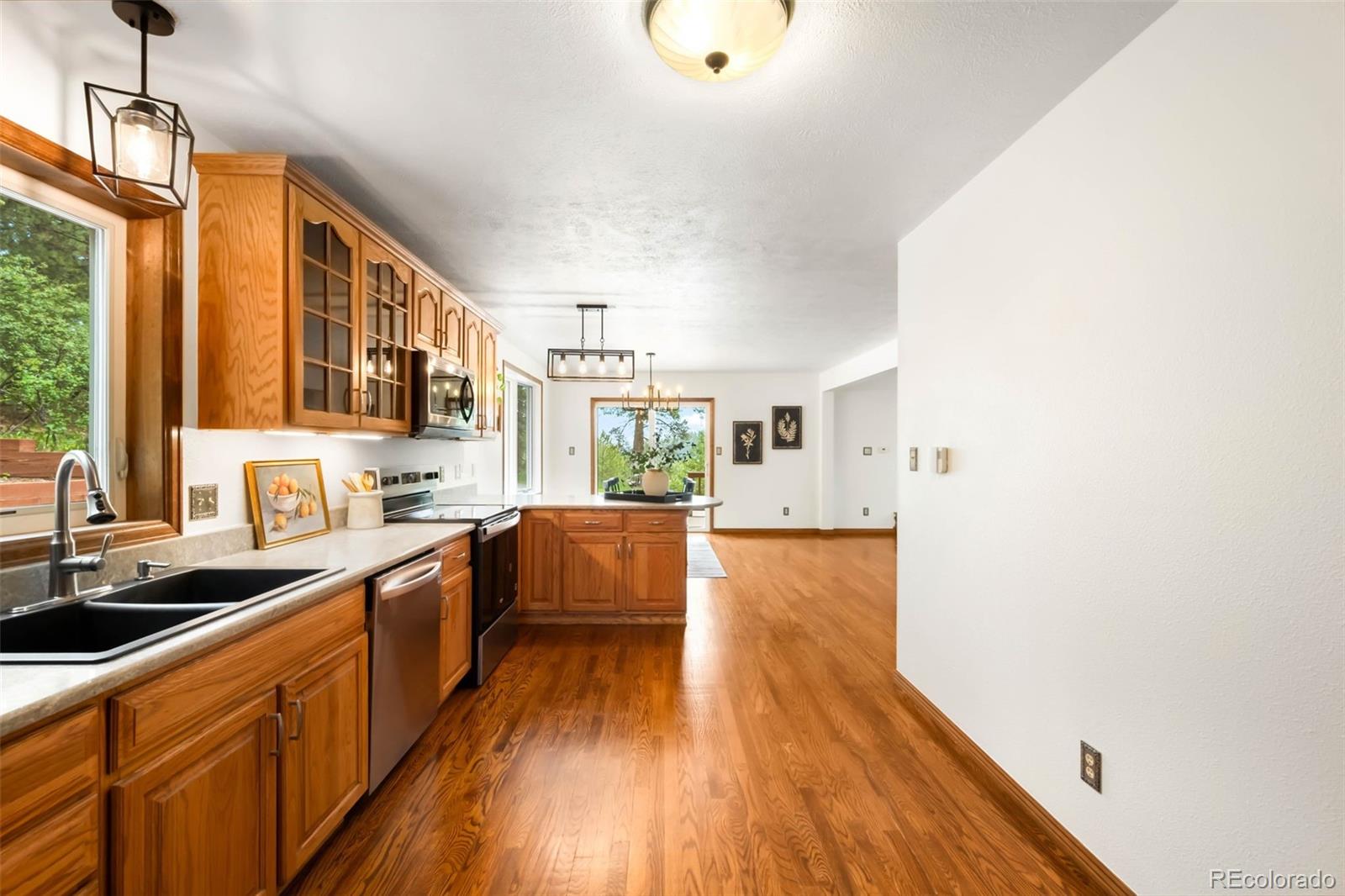 9633 Fox Valley Drive Morrison, CO 80465 - Photo 9 of 50 a large kitchen with a wooden floor and cabinets