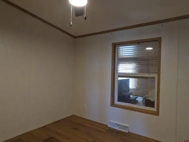 a view of a hallway with a chandelier fan and wooden floor