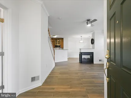 an empty room with wooden floor fireplace and windows