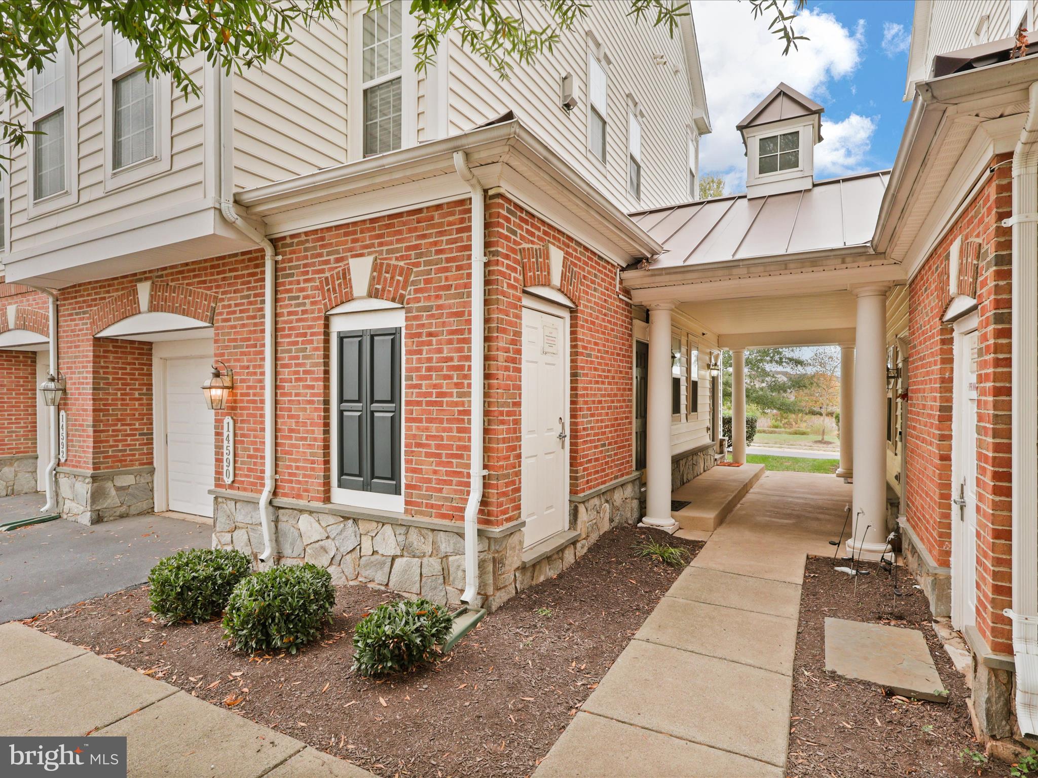 14592 Kylewood Way Gainesville, VA 20155 - Photo 35 of 60 a view of a brick house with many windows and plants
