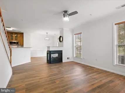 a view of a livingroom with wooden floor and a fireplace