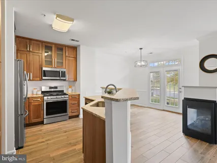 a kitchen with stainless steel appliances granite countertop a sink dishwasher stove and microwave with wooden floor