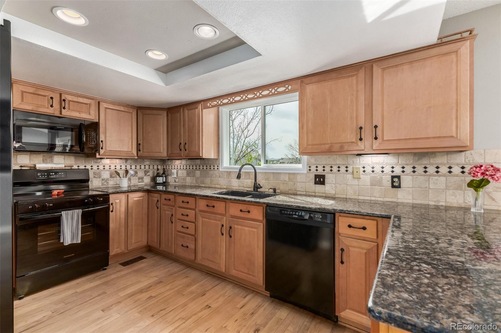 9407 Harvard Drive Highlands Ranch, CO 80130 - Photo 11 of 48 a kitchen with stainless steel appliances granite countertop a stove a sink dishwasher and a microwave oven with cabinets