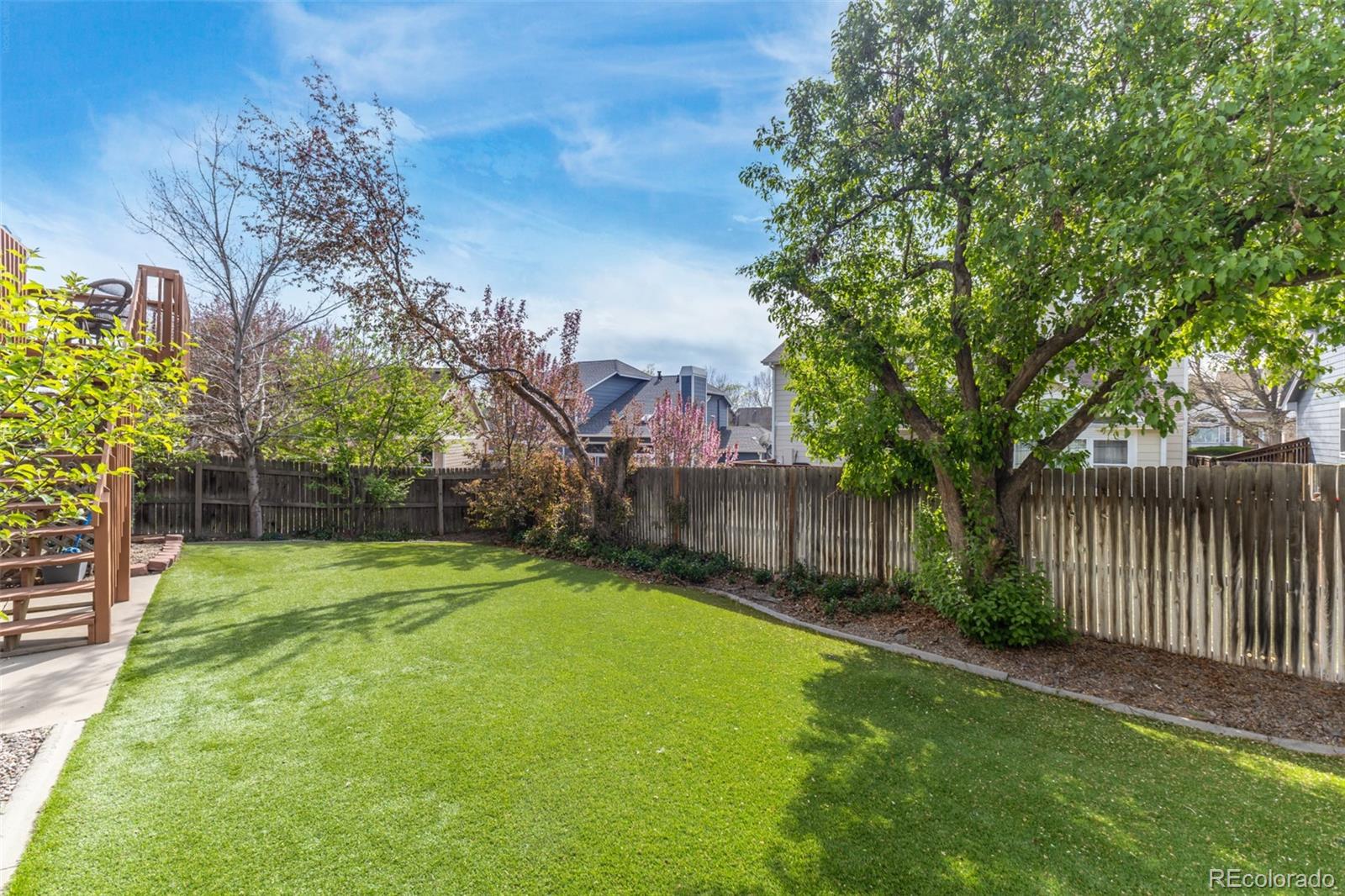 9407 Harvard Drive Highlands Ranch, CO 80130 - Photo 35 of 48 a backyard of a house with table and chairs