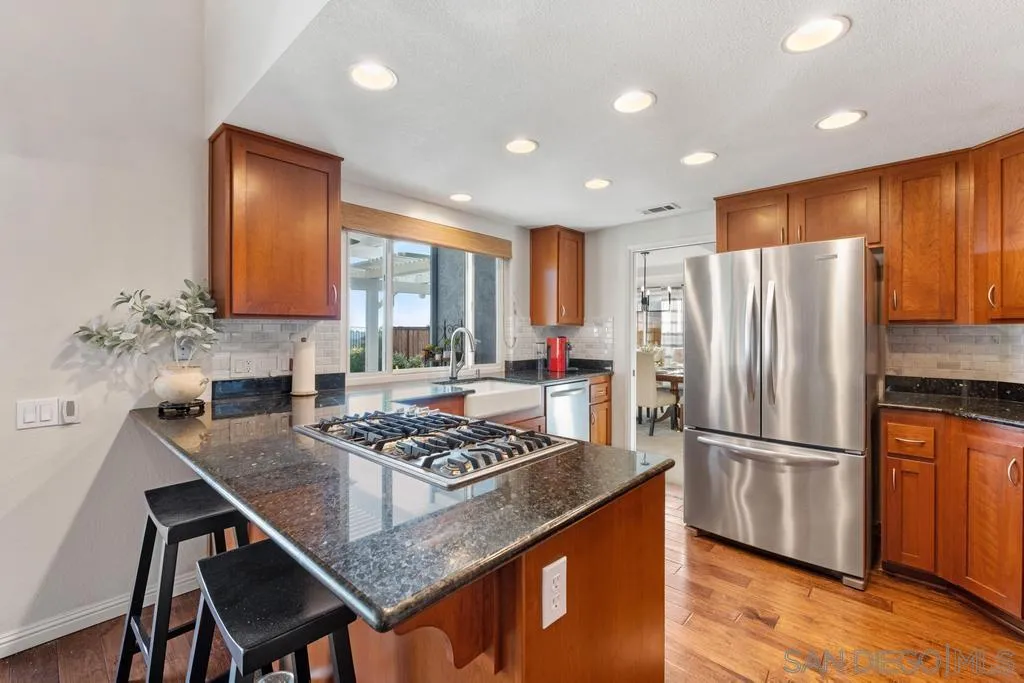 1545 Calle Ryan Encinitas, CA 92024 - Photo 29 of 63 a kitchen with granite countertop stainless steel appliances a refrigerator a stove a sink cabinets and a dining table