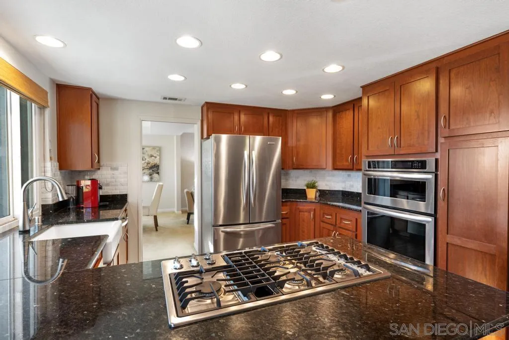 1545 Calle Ryan Encinitas, CA 92024 - Photo 30 of 63 a kitchen with stainless steel appliances granite countertop a refrigerator stove and sink