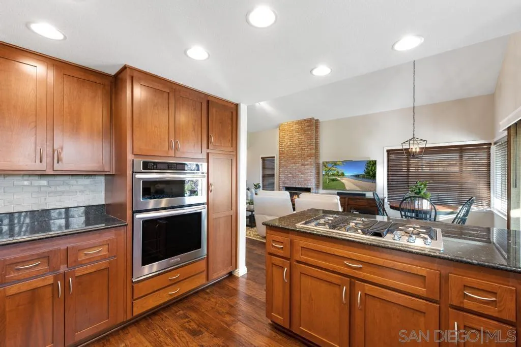 1545 Calle Ryan Encinitas, CA 92024 - Photo 34 of 63 a kitchen with stainless steel appliances granite countertop a sink a stove and a wooden cabinets