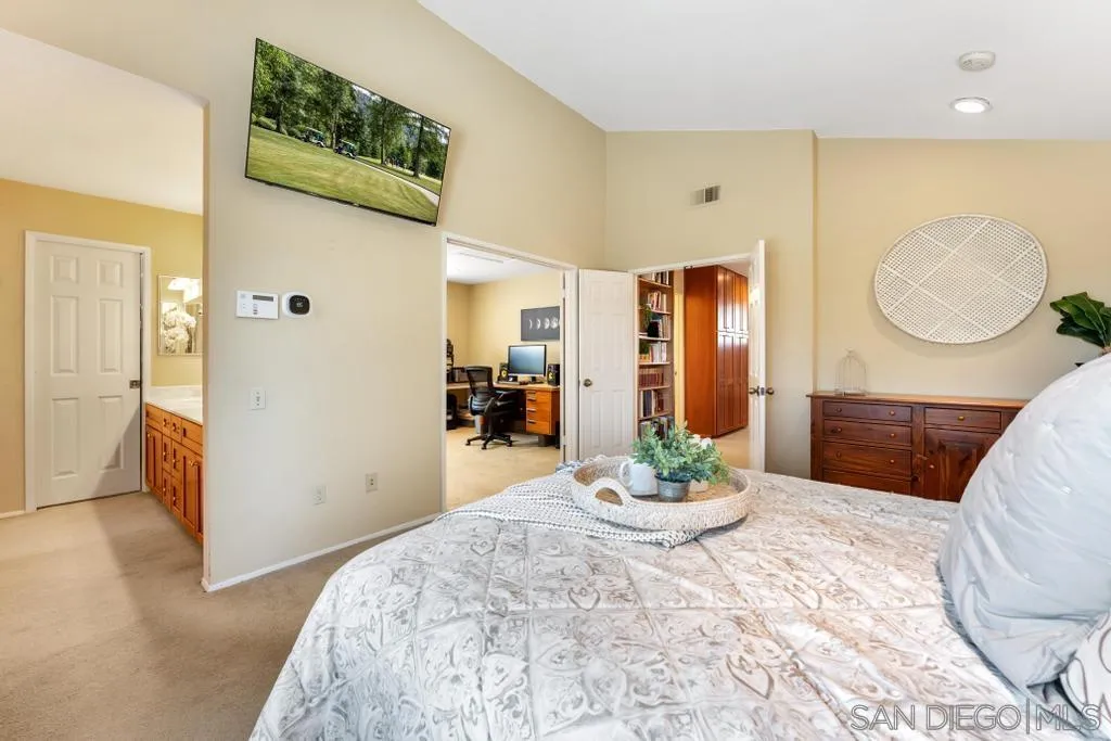 1545 Calle Ryan Encinitas, CA 92024 - Photo 47 of 63 a bedroom with a bed and dresser with mirror