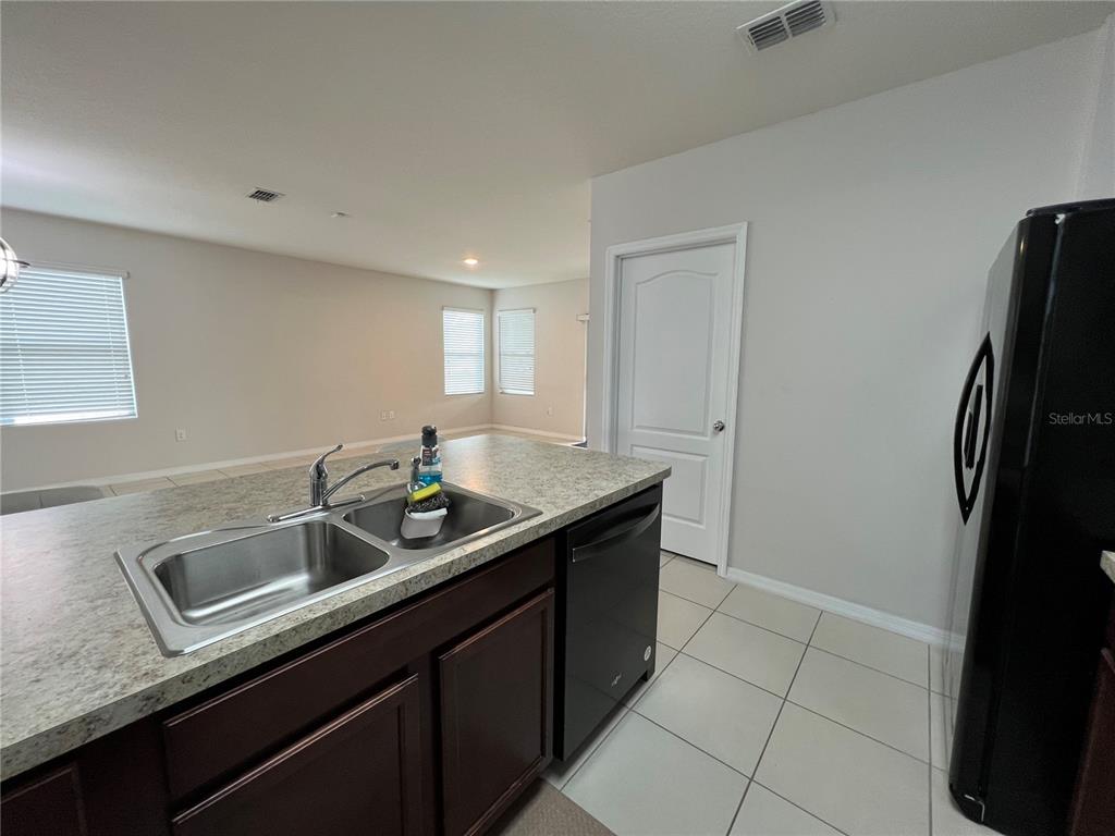 1756 Brockridge Road Kissimmee, FL 34744 - Photo 14 of 26 a kitchen with stainless steel appliances granite countertop a sink and a refrigerator