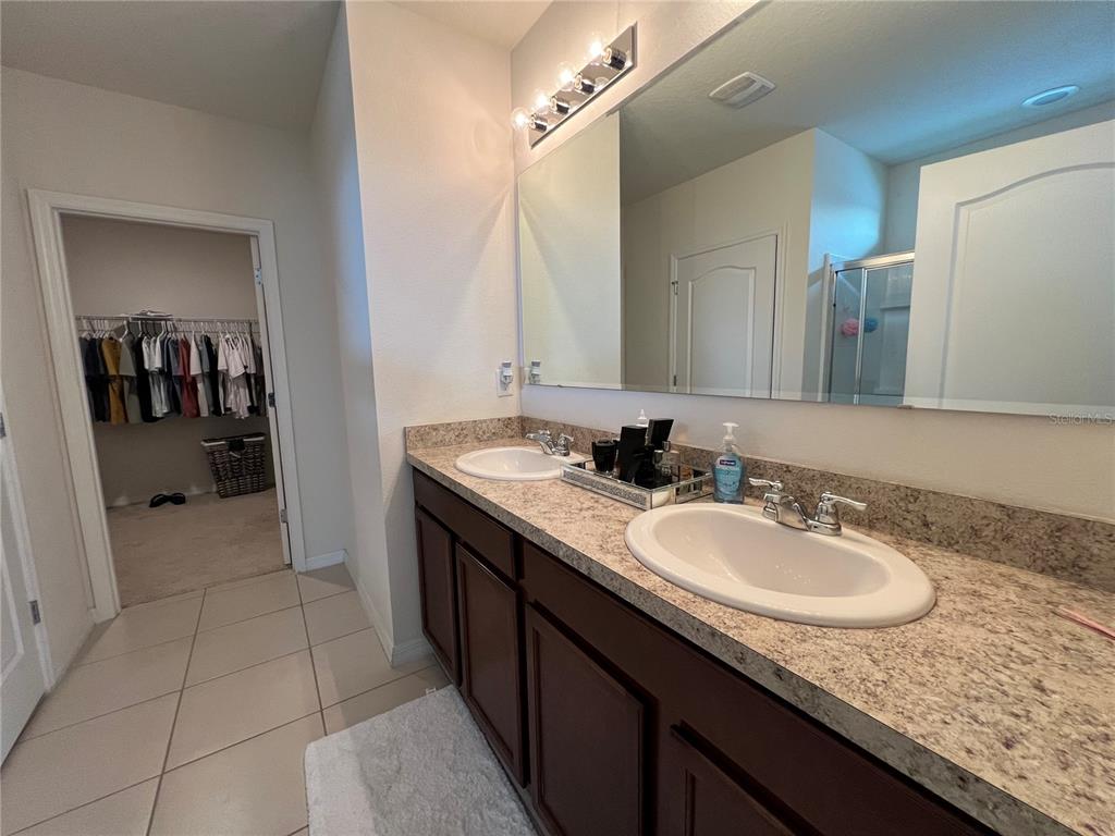 1756 Brockridge Road Kissimmee, FL 34744 - Photo 18 of 26 a en suite bathroom with a granite countertop sink and a mirror