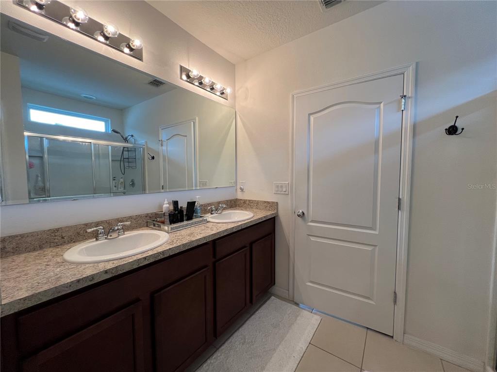 1756 Brockridge Road Kissimmee, FL 34744 - Photo 19 of 26 a bathroom with a granite countertop sink and a mirror