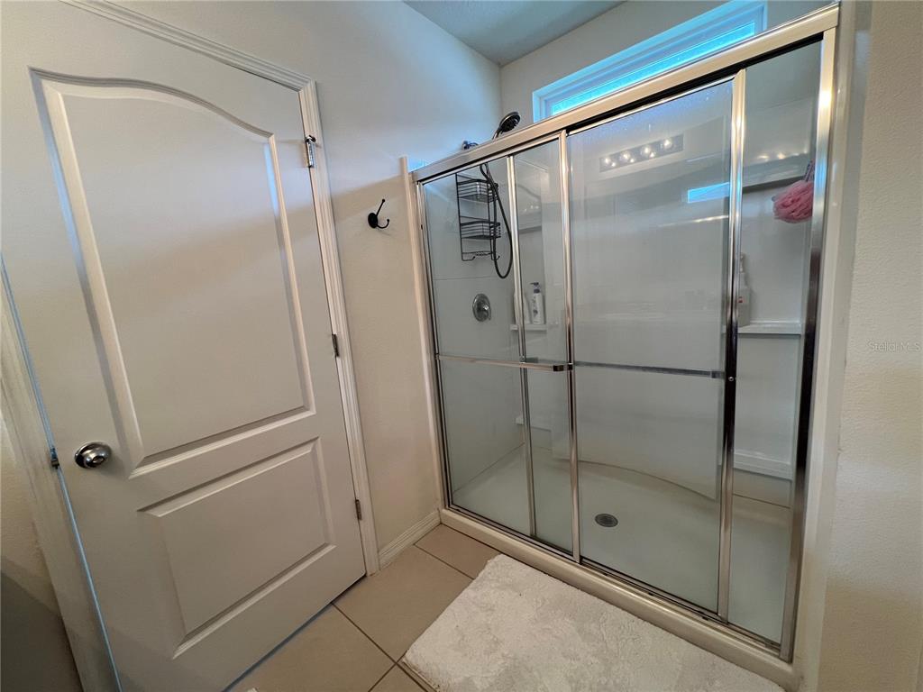 1756 Brockridge Road Kissimmee, FL 34744 - Photo 20 of 26 a bathroom with a glass shower door