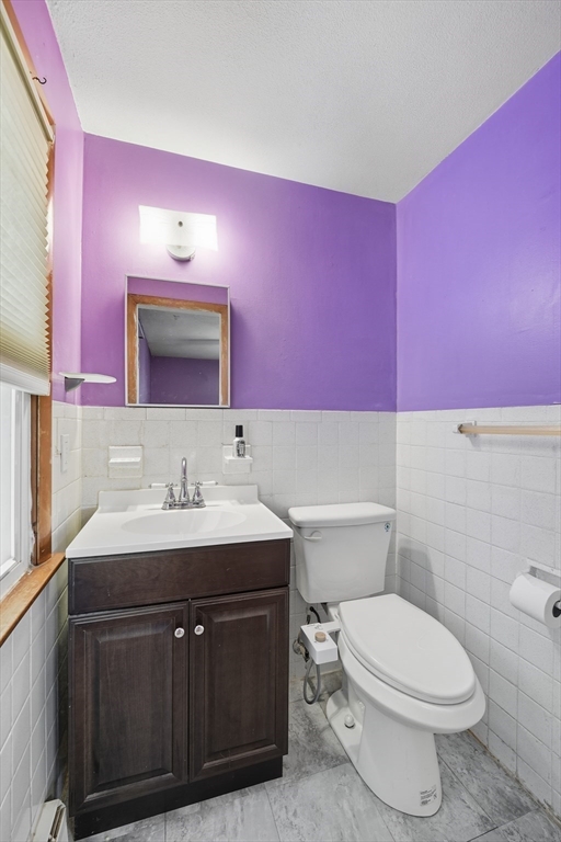 794 Homestead Avenue Holyoke, MA 01040 - Photo 19 of 34 a bathroom with a toilet a sink a mirror and vanity