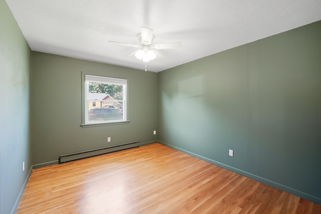 794 Homestead Avenue Holyoke, MA 01040 - Photo 27 of 34 an empty room with wooden floor and fan