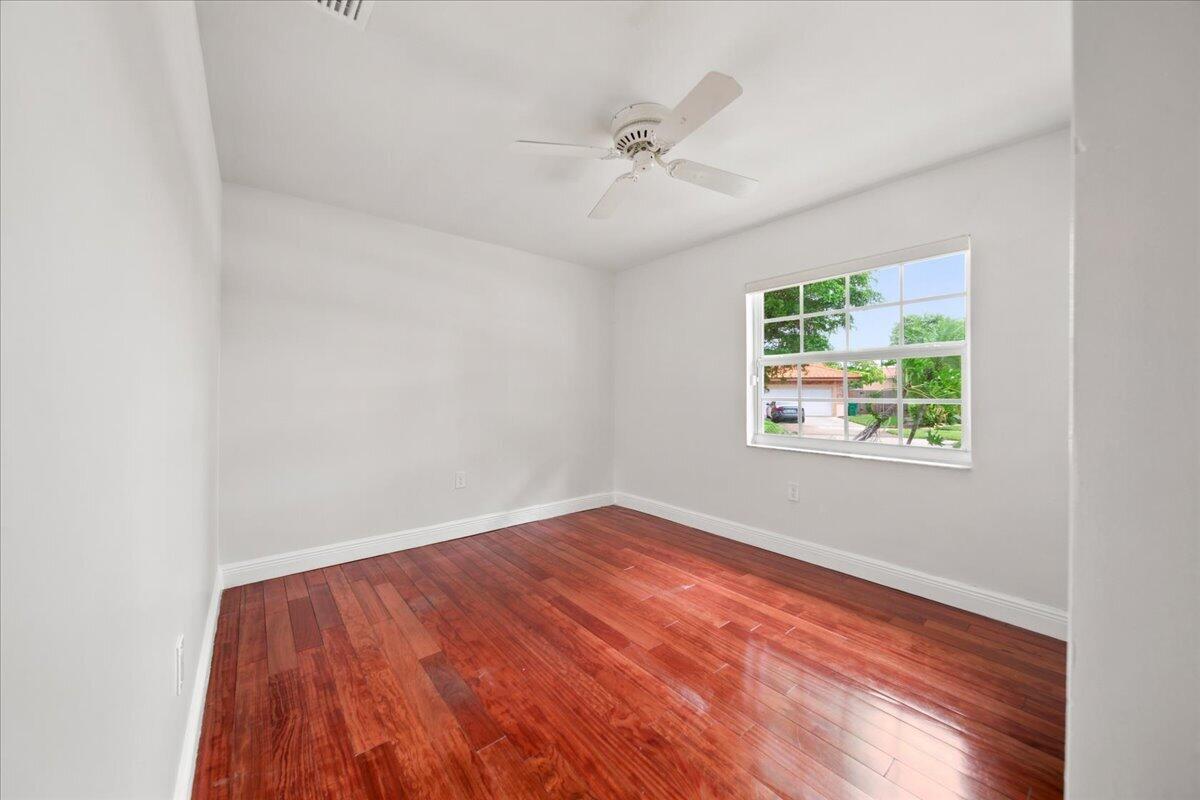 20009 Northwest 66th Place Hialeah, FL 33015 - Photo 25 of 33 an empty room with wooden floor chandelier fan and windows