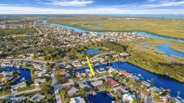an aerial view of residential houses with outdoor space and ocean view